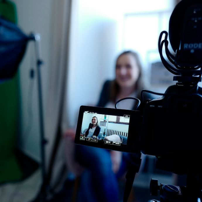 a woman sitting in front of a green screen