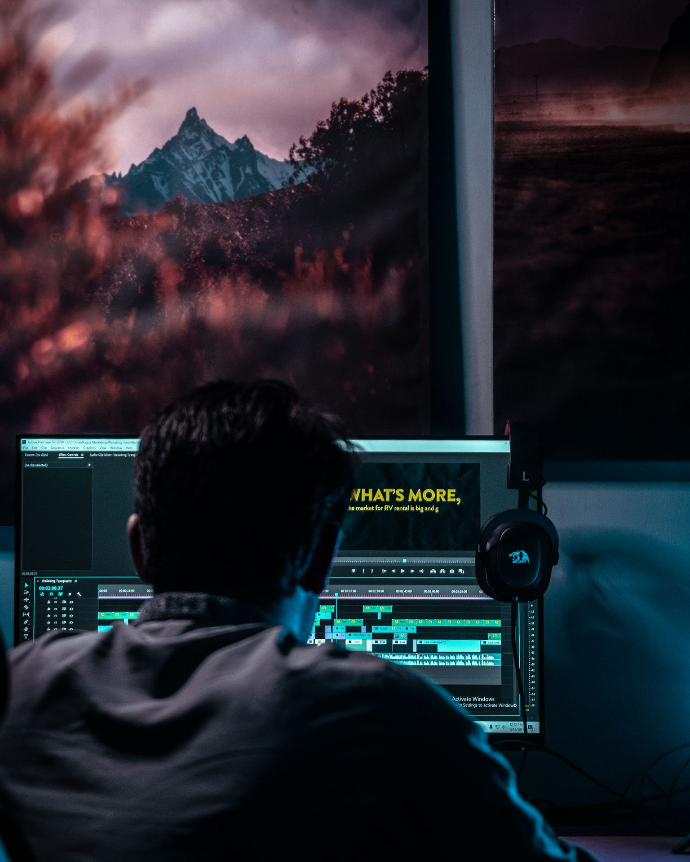 a man sitting in front of a computer monitor